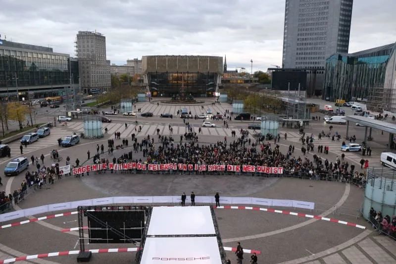 Activists hold up the slogan "Tell me who you're partying with and I'll tell you who you are" as they gather on Augustusplatz to protest against the participation of Rammstein singer Lindemann at the Leipzig Opera Ball. Sebastian Willnow/dpa